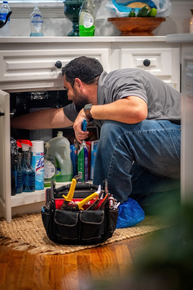 Jean working on a repair under the sink