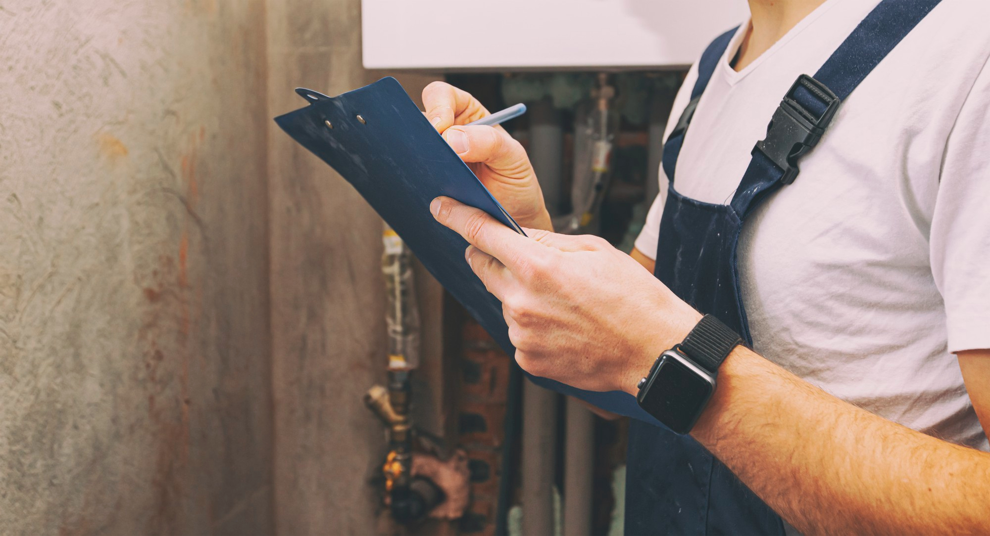 Home Plumbing & Sewer Inspection in Greenville SC - Man holding clipboard inspecting the plumbing system