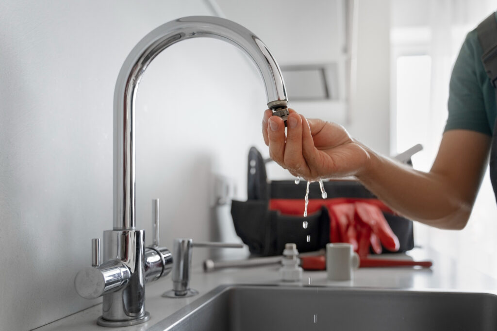 greenville faucet repair - man repairing leaking faucet