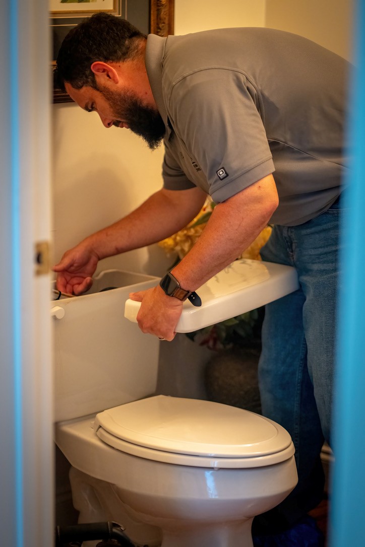 Jean Castro, Owner of JB Plumbing Services, fixing a toilet